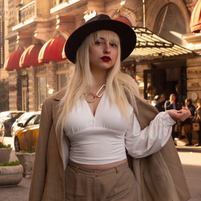 Stylish woman in Istanbul wearing a chic hat and beige suit. Capturing urban elegance.