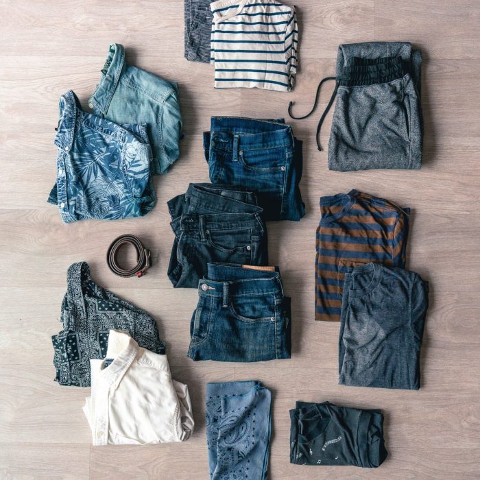 Neatly arranged casual clothes in a flat lay style on wooden floor.